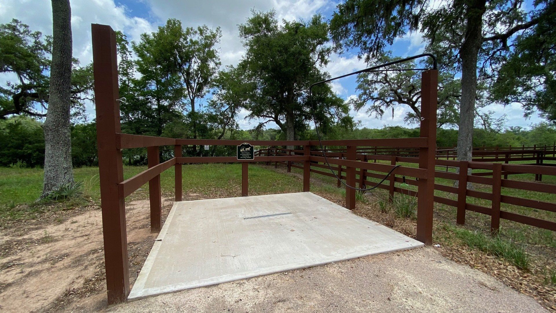 a wooden fence surrounds a concrete platform in a field .