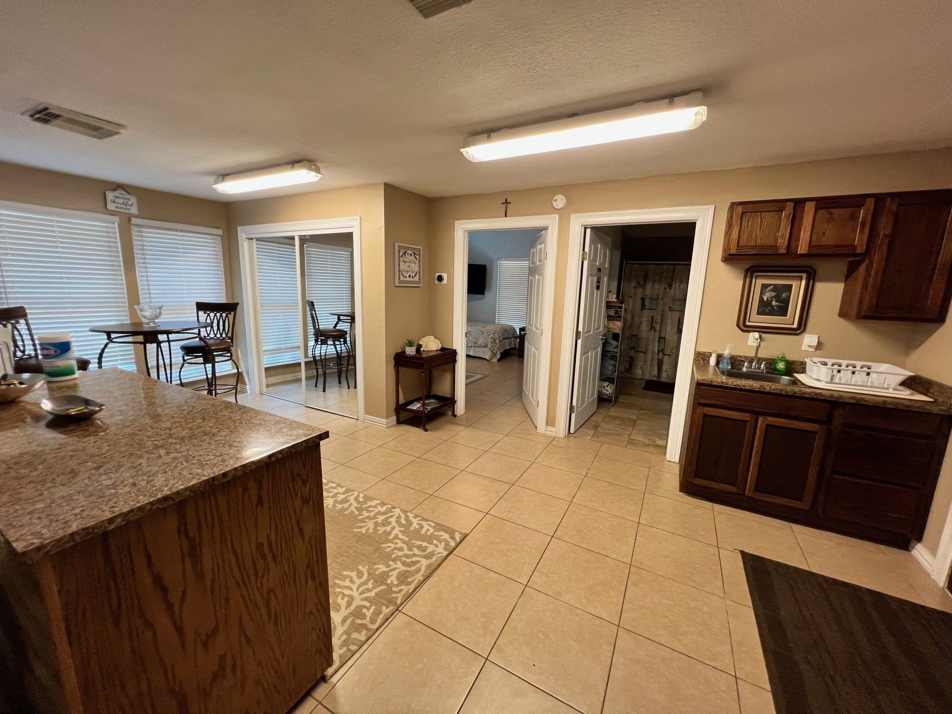 a kitchen with a large island , cabinets , a sink and a dining table .