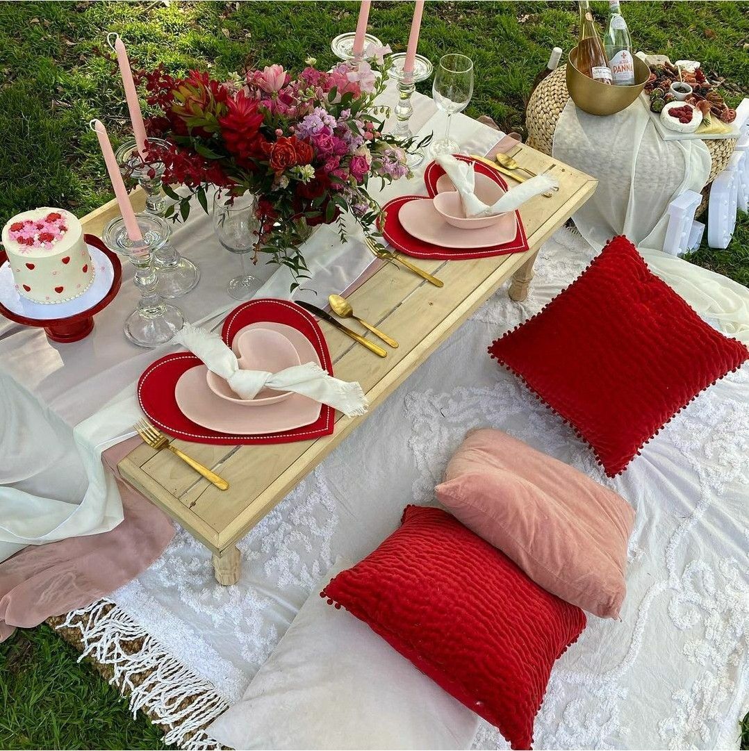 a picnic table with plates , candles , and flowers on it .