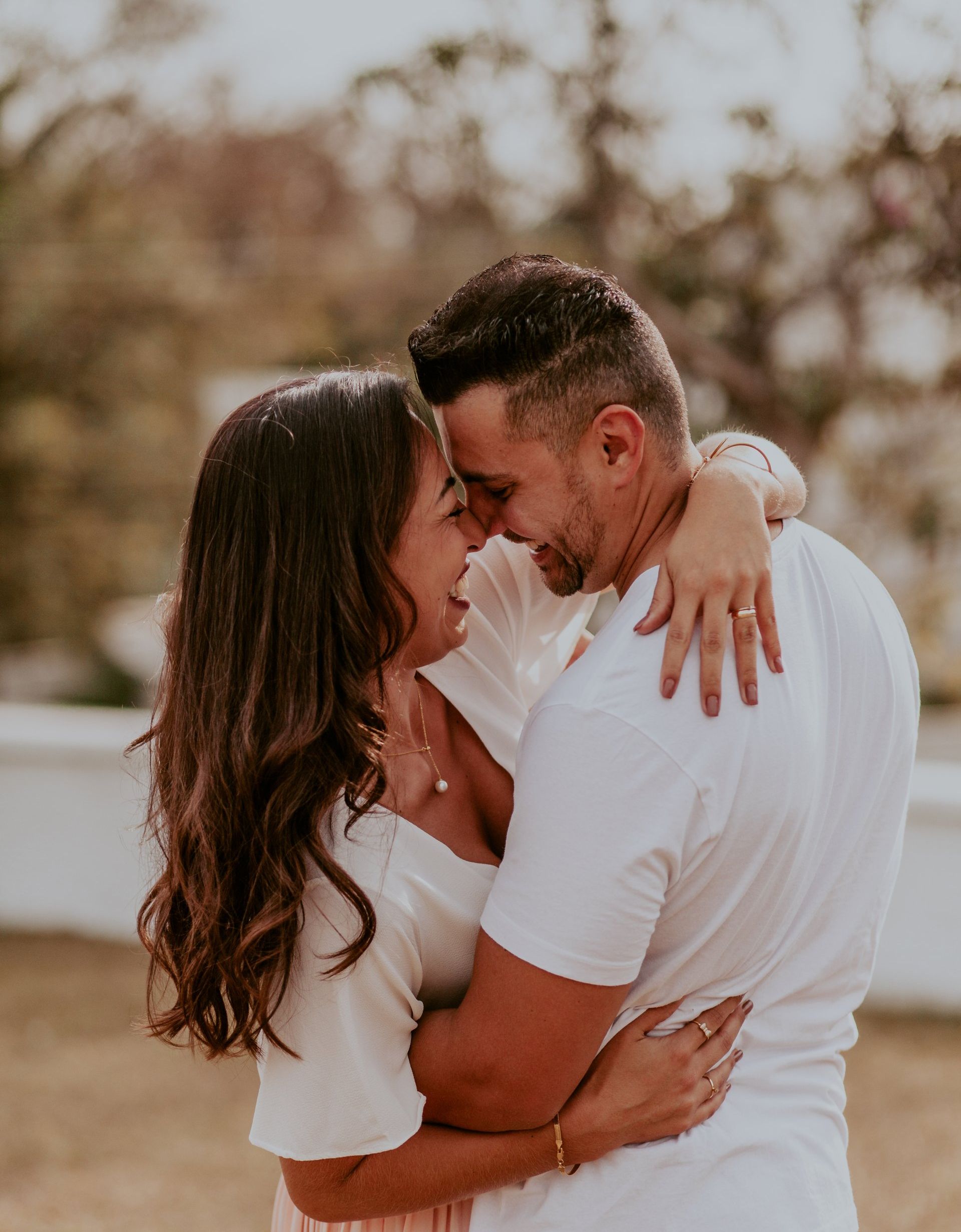 a man and a woman are hugging each other and looking at each other .