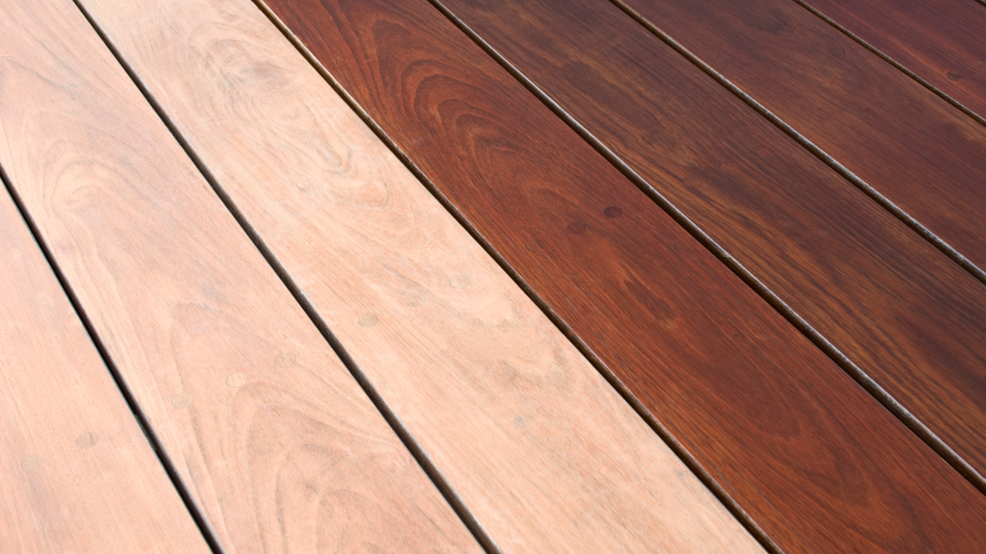 A side-by-side comparison of light, natural wood decking planks and dark, stained wood planks.