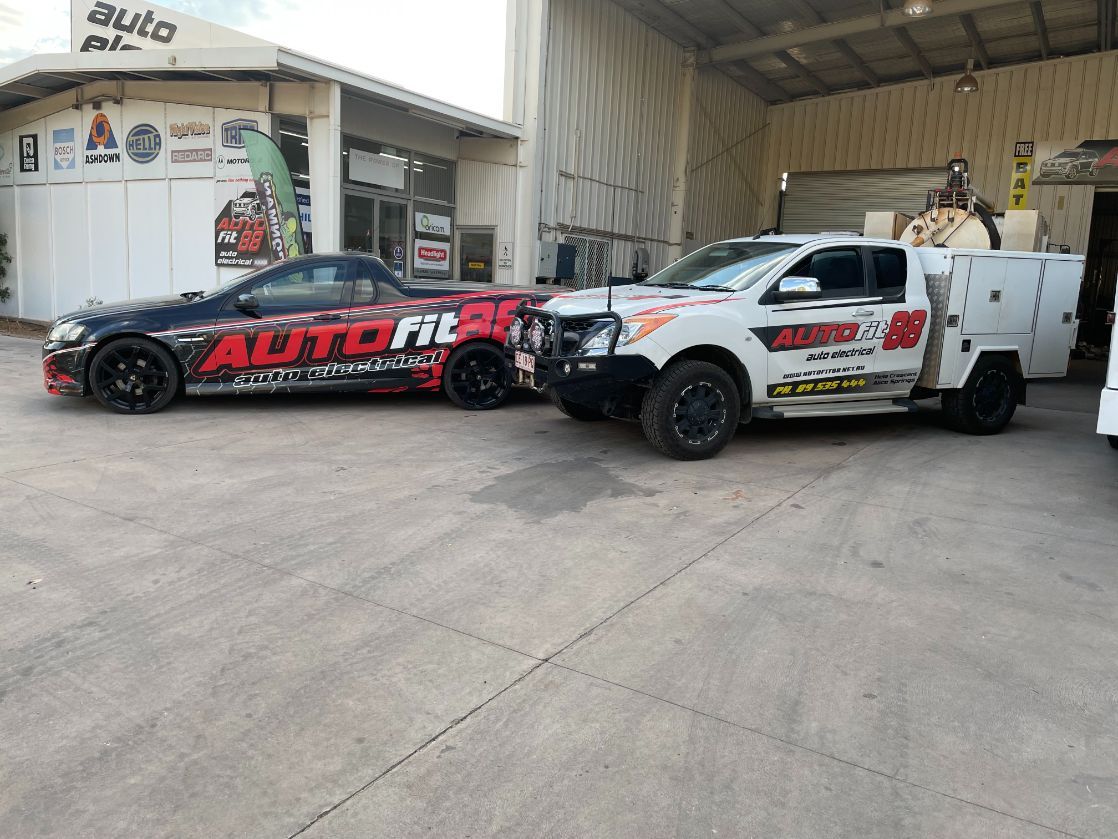 Two Cars Are Parked Next To Each Other In Front Of A Building — Autofit88 Auto Electrics In Ciccone, NT