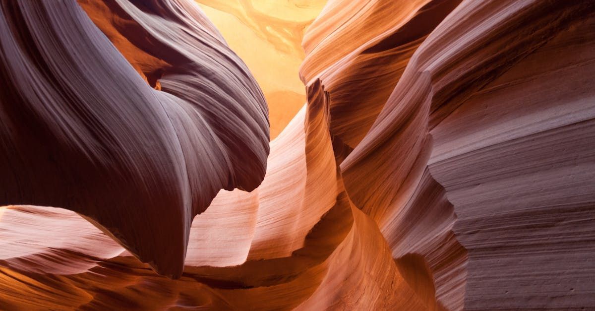 Sandstone canyon walls in shades of orange and brown, with light streaming from above.