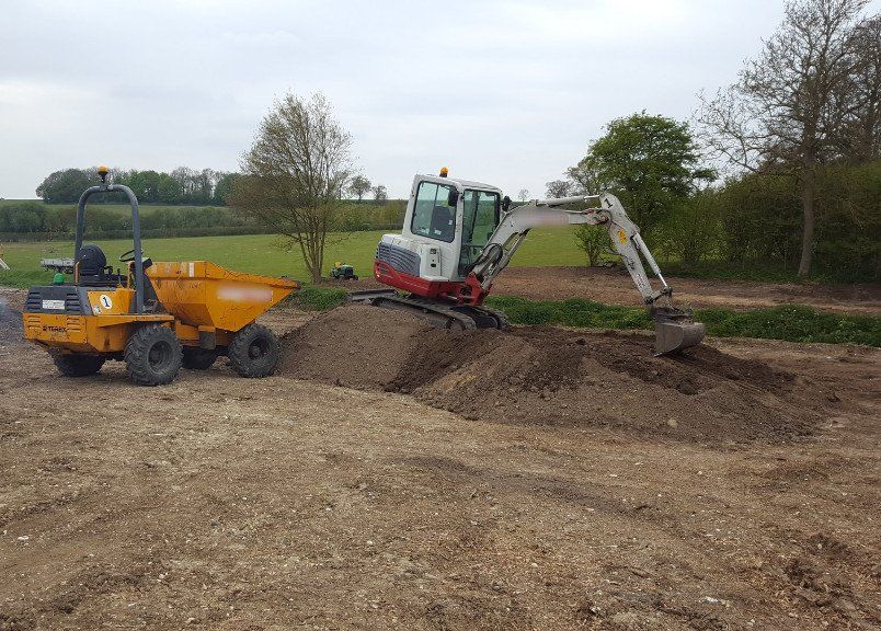 digger and dumper clearing ground