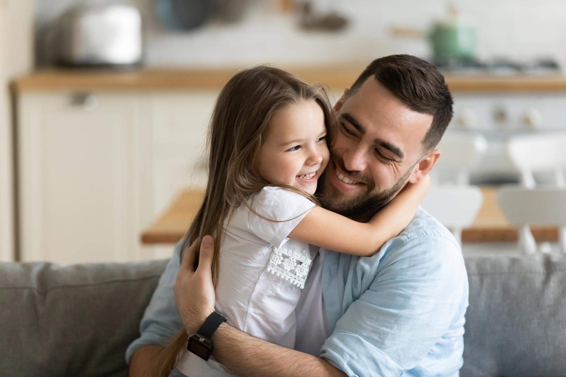 Close-up-smiling-loving-young-father-hugging-adorable-little-daughter