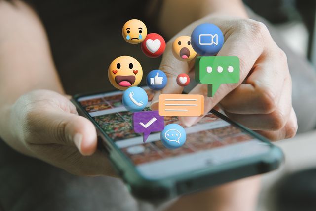 Hands using a smartphone with floating social media notification icons and chat bubbles