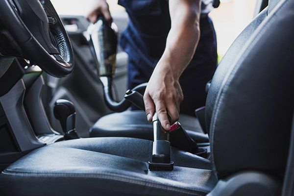 Car Cleaner Vacuuming Drivers Seat — Issaquah, WA — David’s Auto Detailing