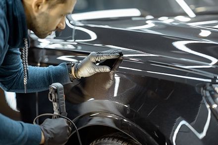 Worker Examining Vehicle Body for Scratches — Issaquah, WA — David’s Auto Detailing