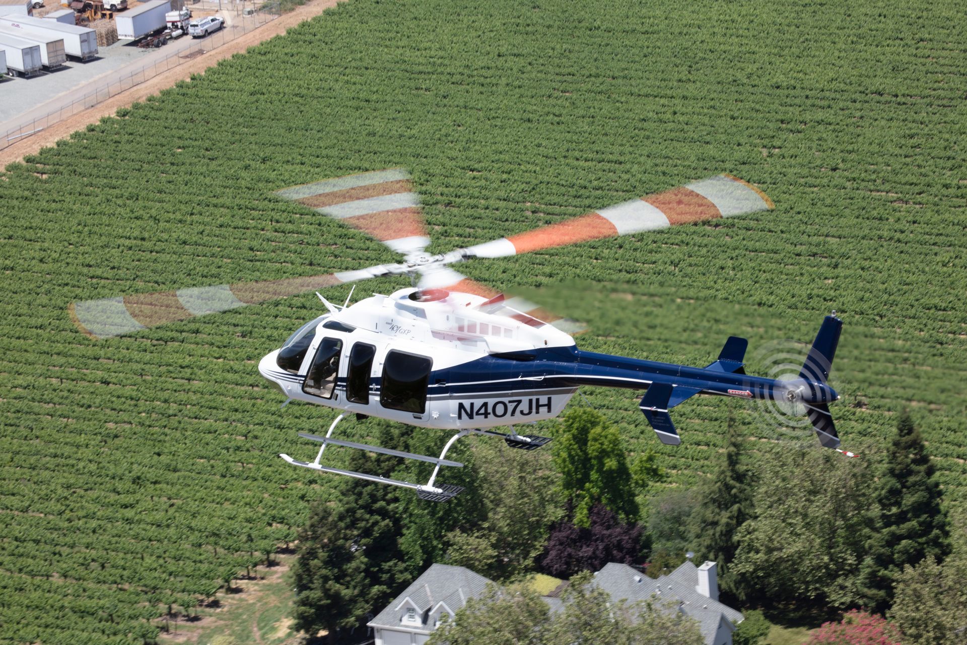 An aerial view of a helicopter flying over a vineyard