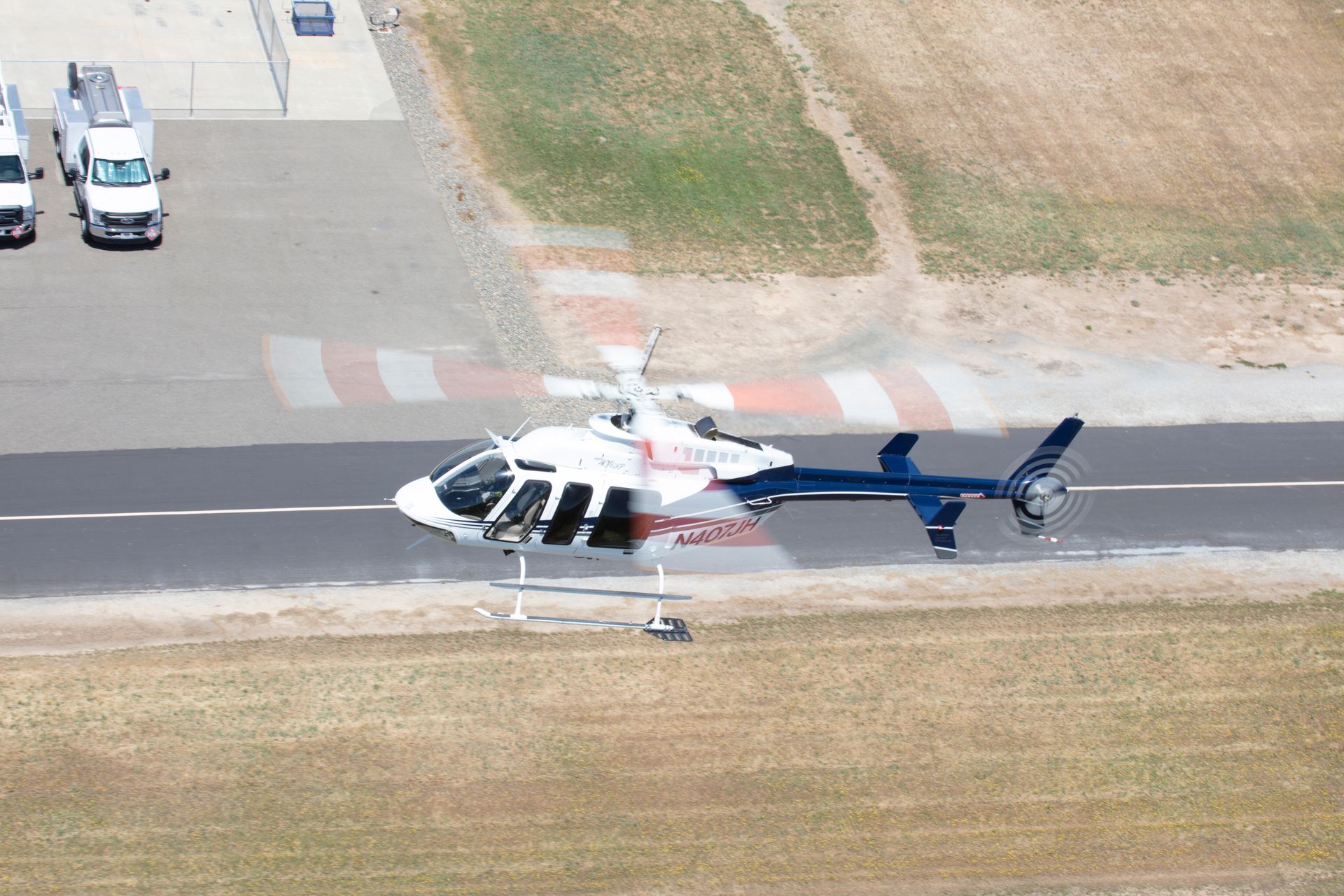 A helicopter is taking off from an airport runway