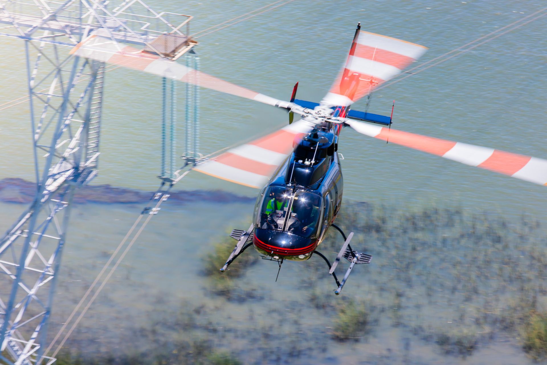 A helicopter is flying over a body of water