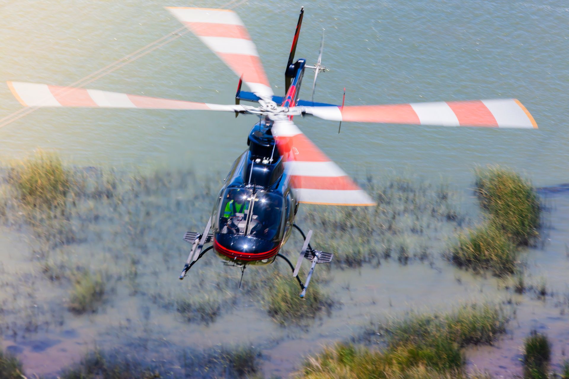 A helicopter is flying over a body of water.