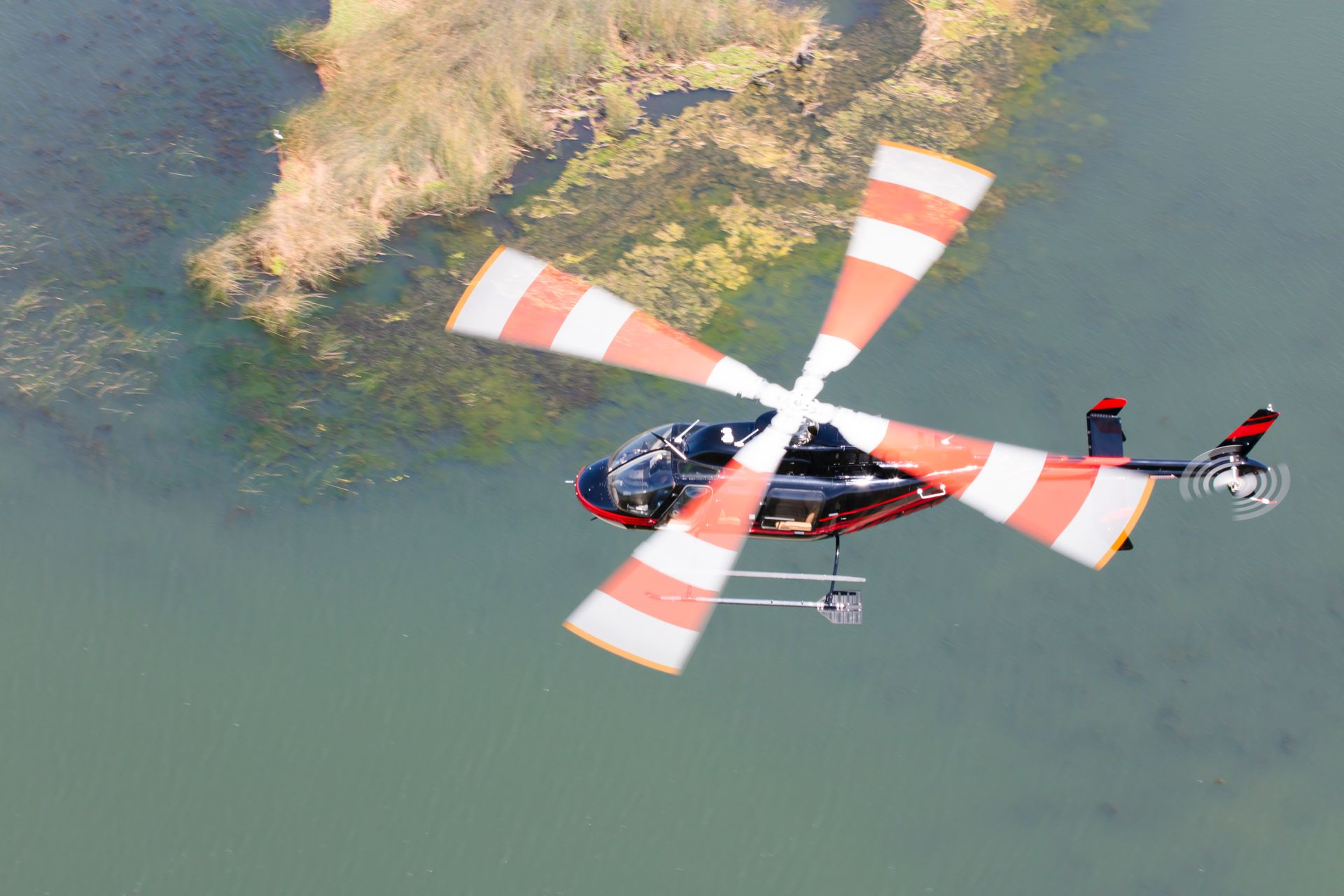 A helicopter is flying over a body of water