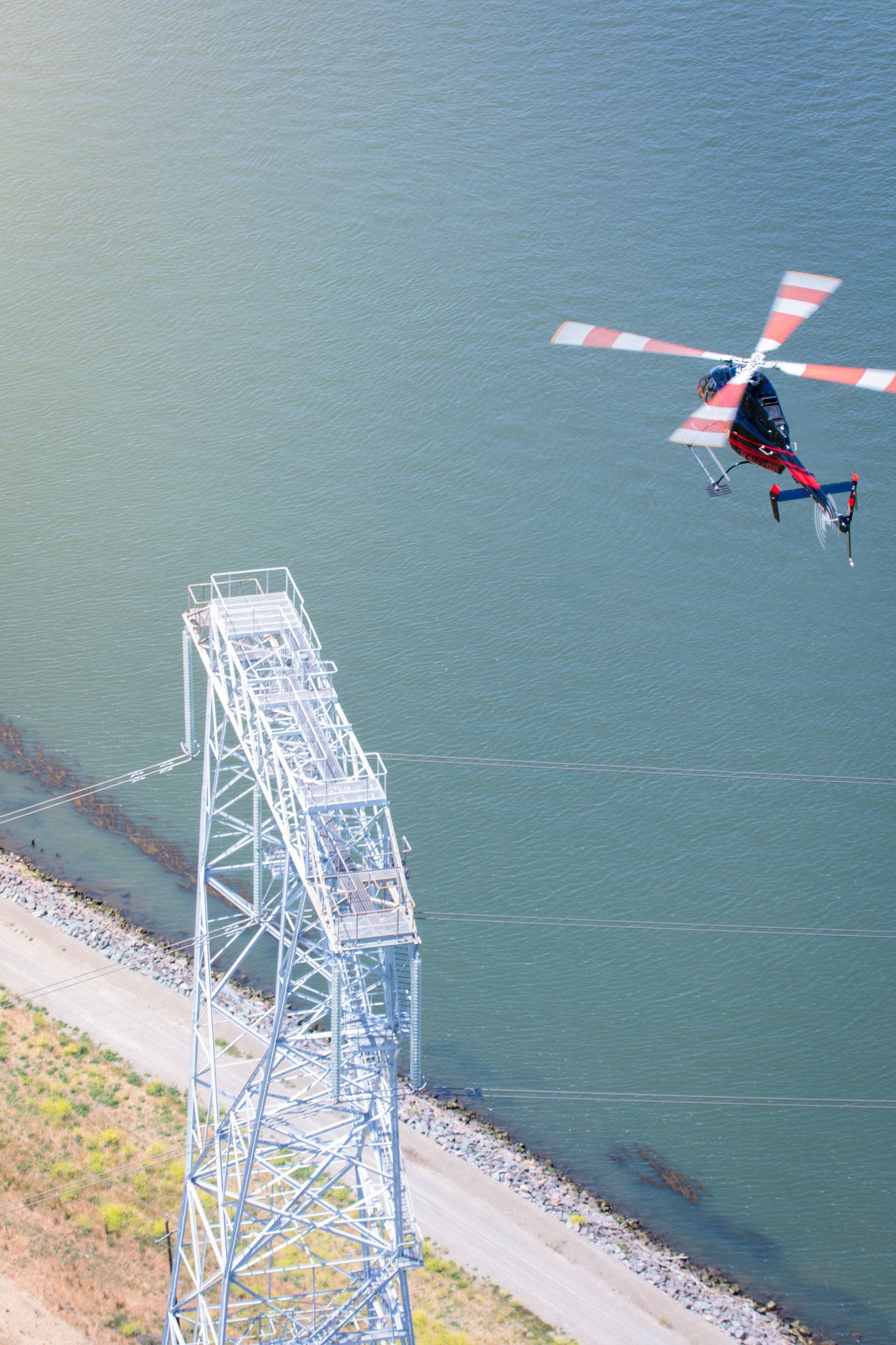 A helicopter is flying over a body of water.