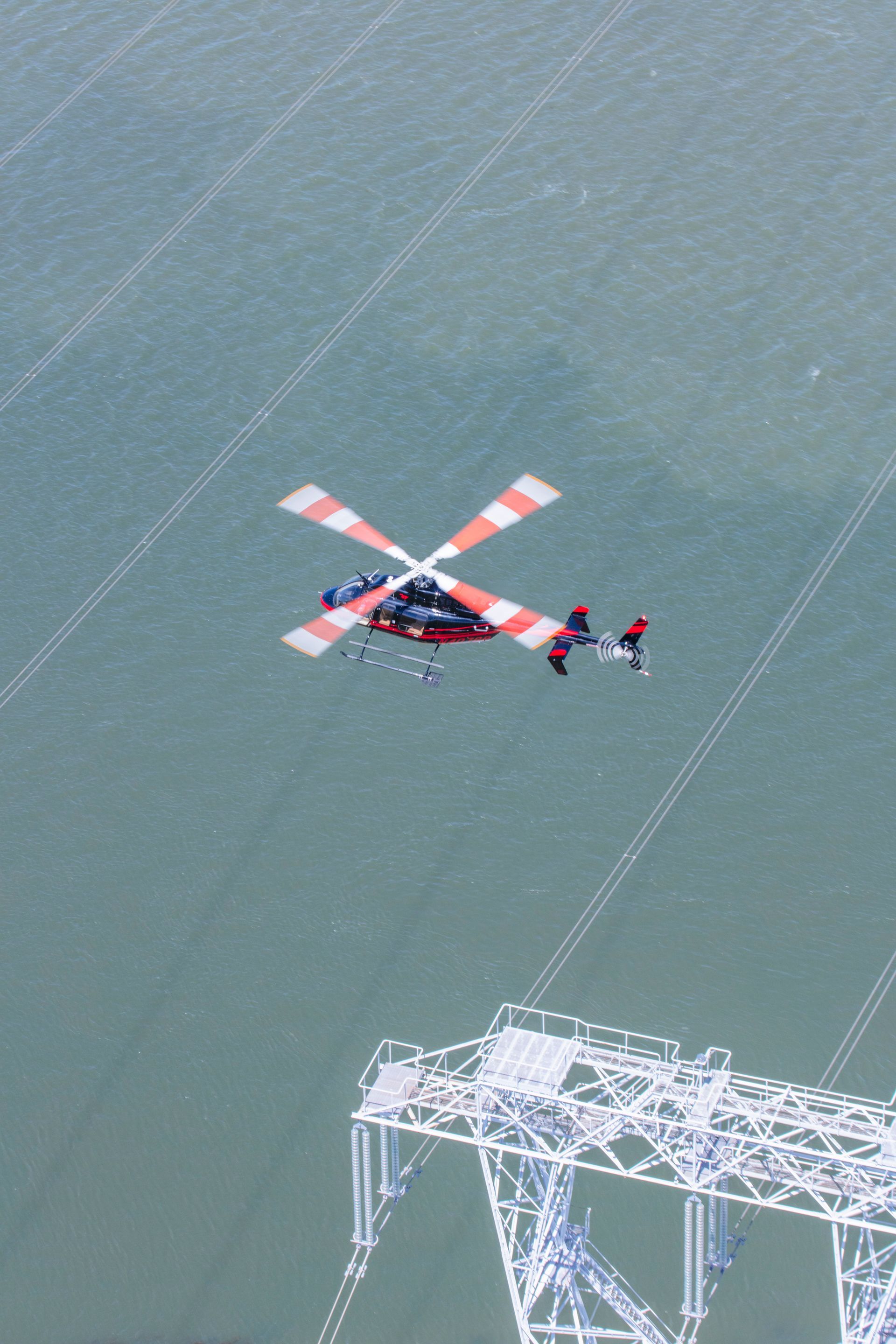 A helicopter is flying over a body of water