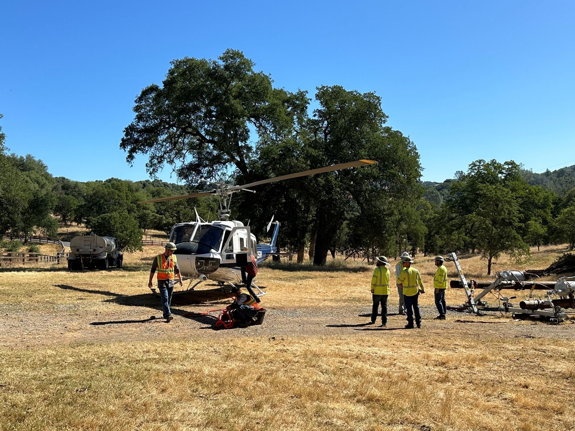 A group of people standing around a helicopter in a field