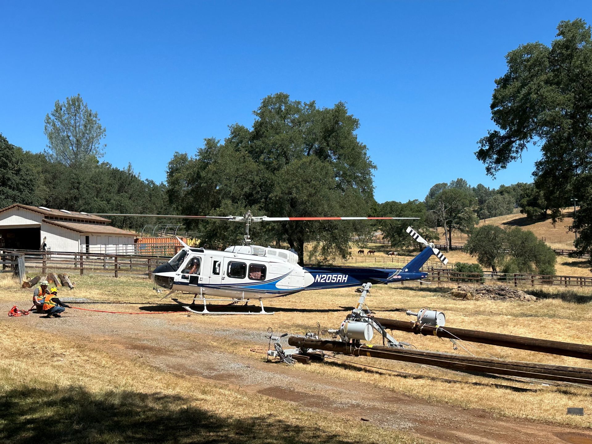 A helicopter is parked in a field with trees in the background