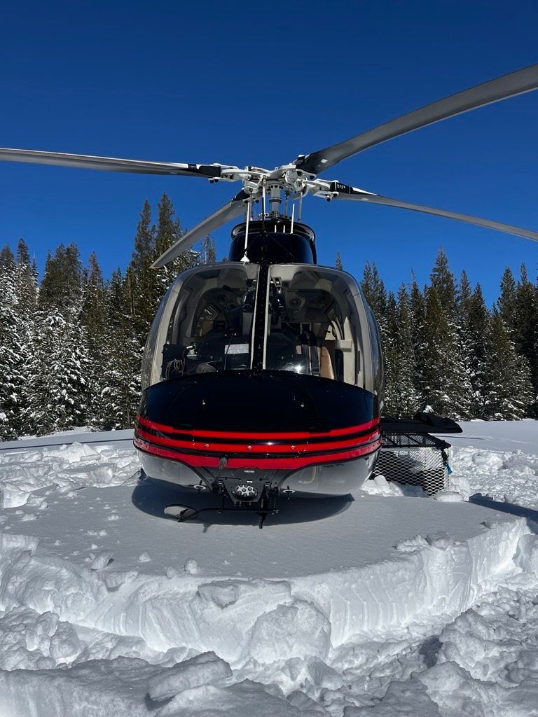 A helicopter is sitting on top of a snow covered field