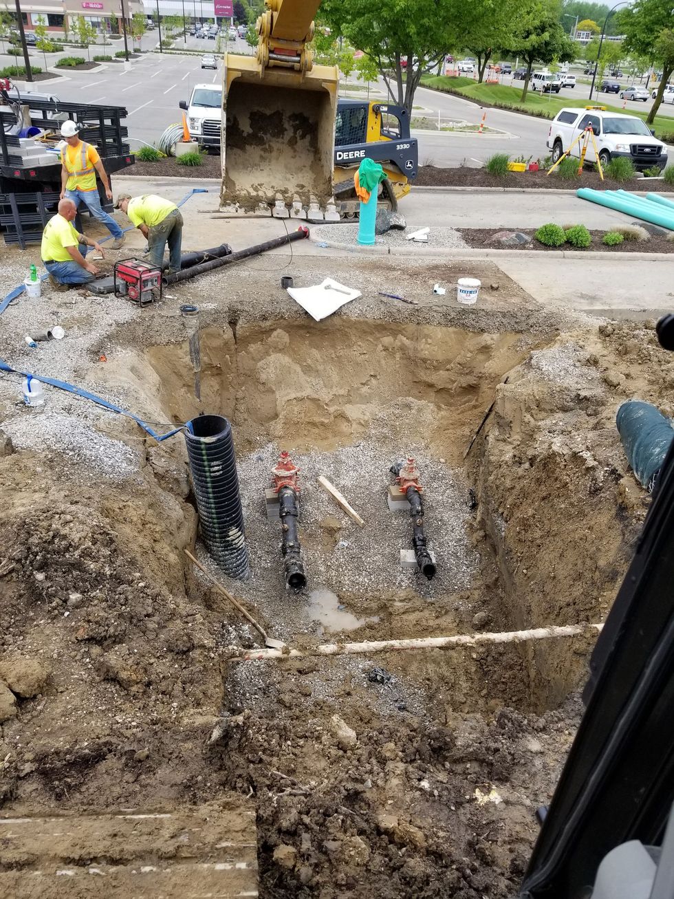 A group of construction workers are digging a hole in the ground.