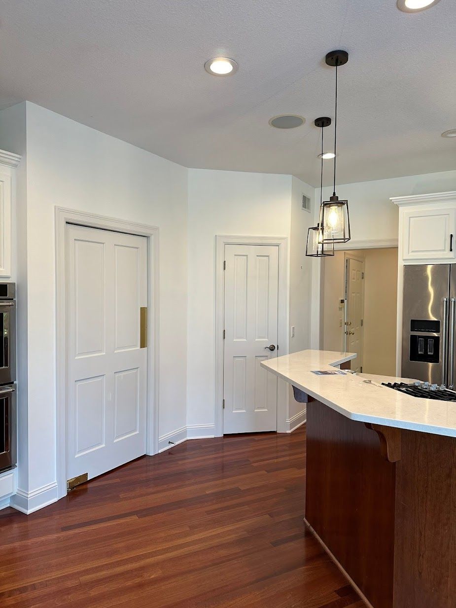A kitchen with stainless steel appliances and wooden floors