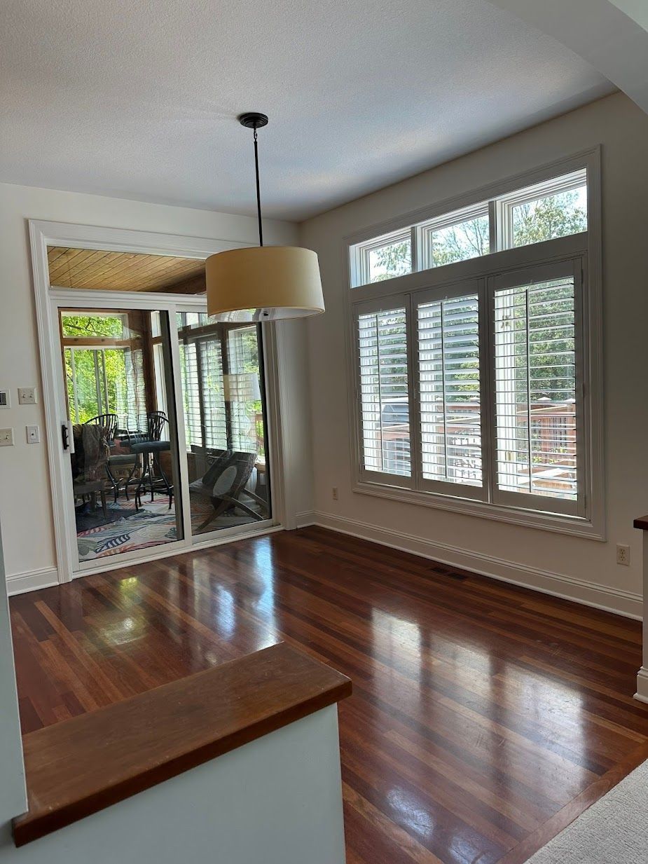 A living room with hardwood floors and lots of windows