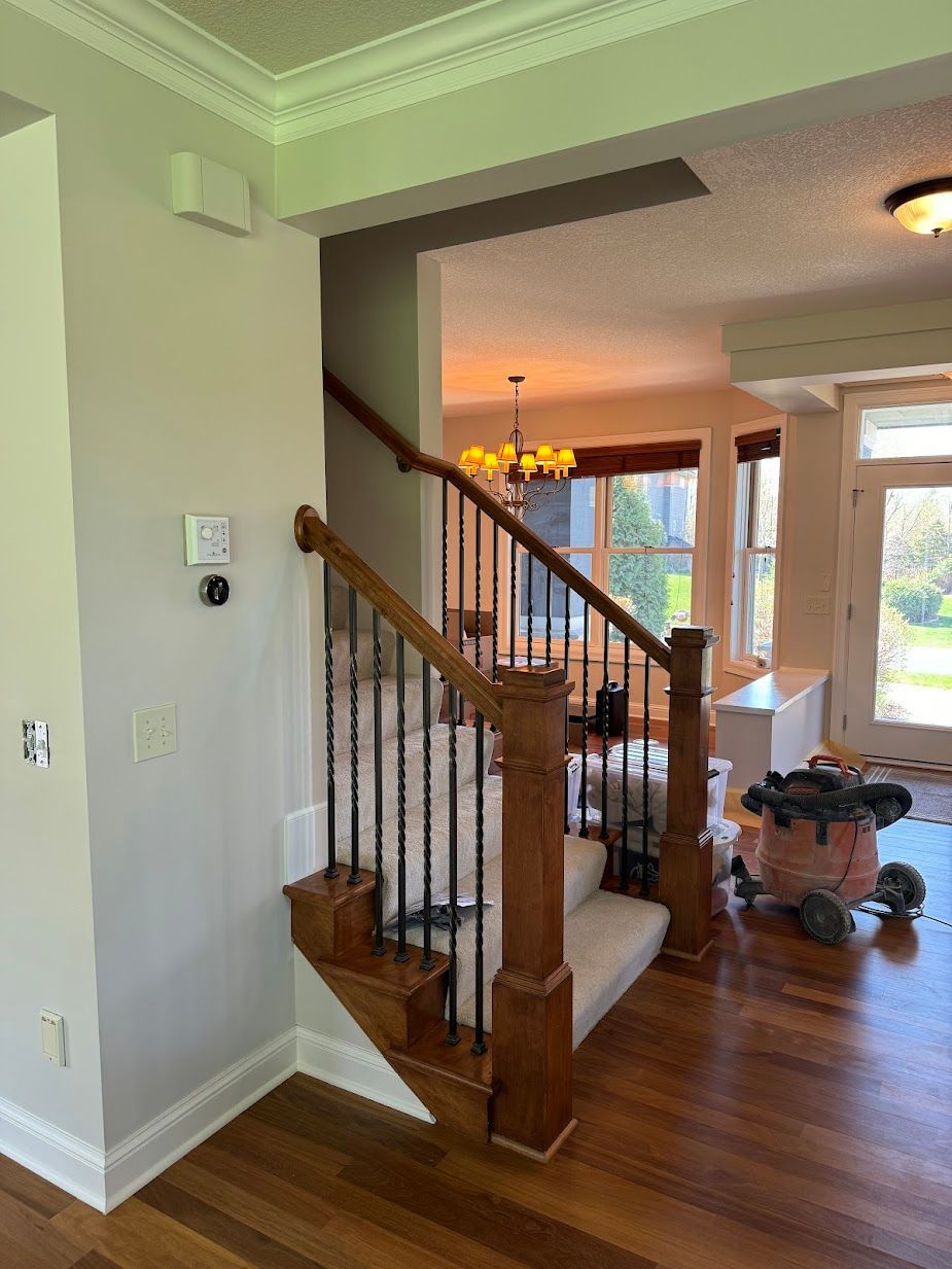 A wooden staircase with a metal railing in a house.