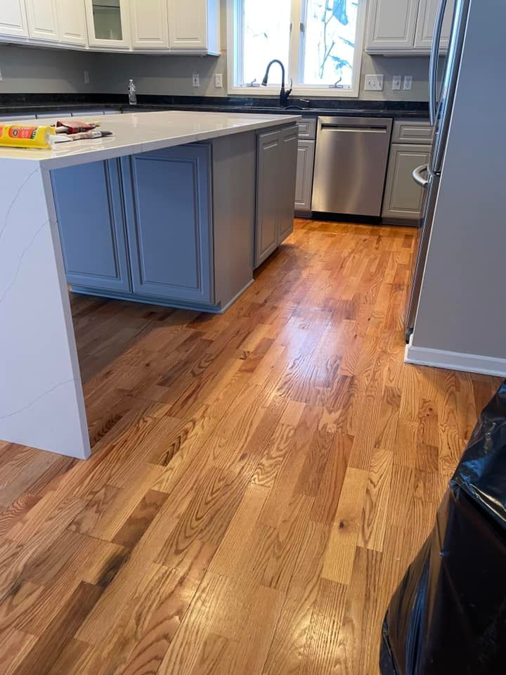 A kitchen with hardwood floors and stainless steel appliances.