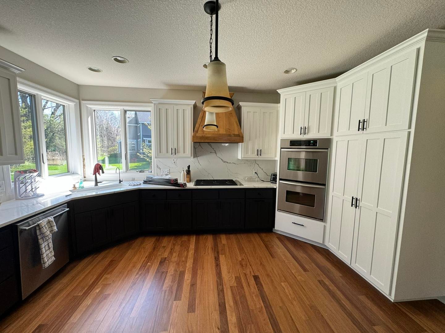 A kitchen with wooden floors and white cabinets