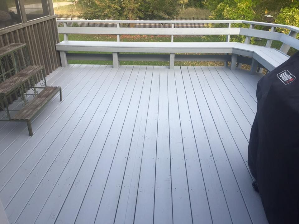 A white deck with a bench and a grill