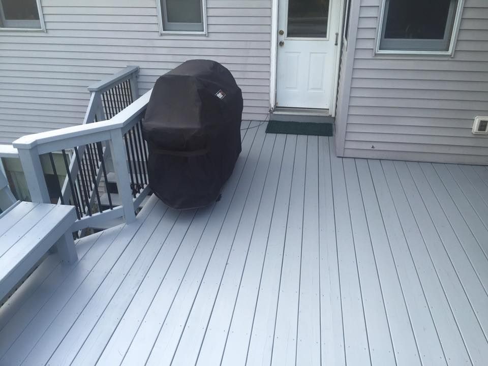 A grill is sitting on a deck next to a house