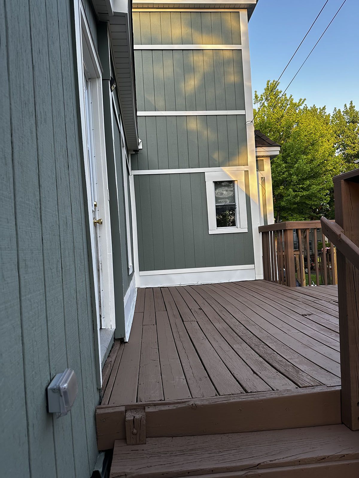 A wooden deck with stairs leading up to a house