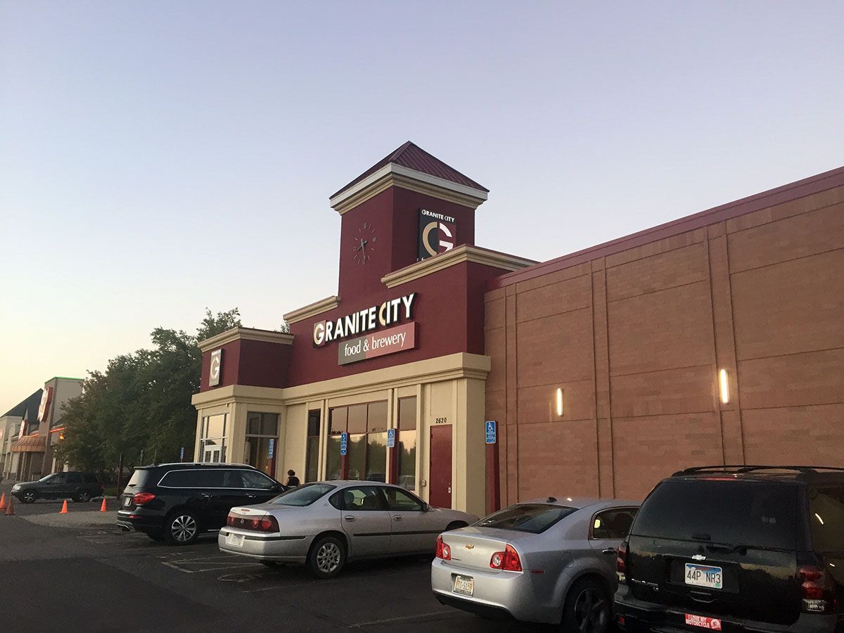 A group of cars are parked in front of a store called grant city