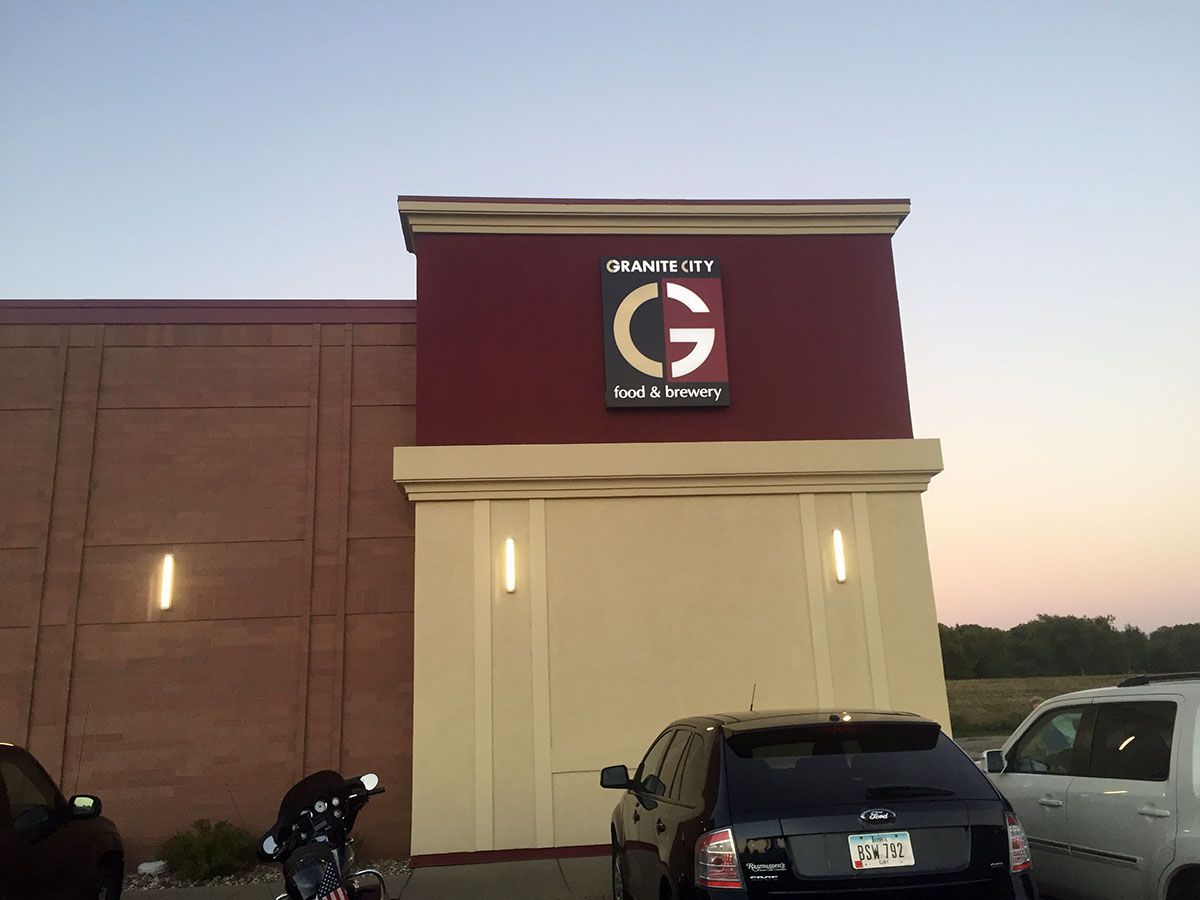 A car is parked in front of a building with the letter g on it