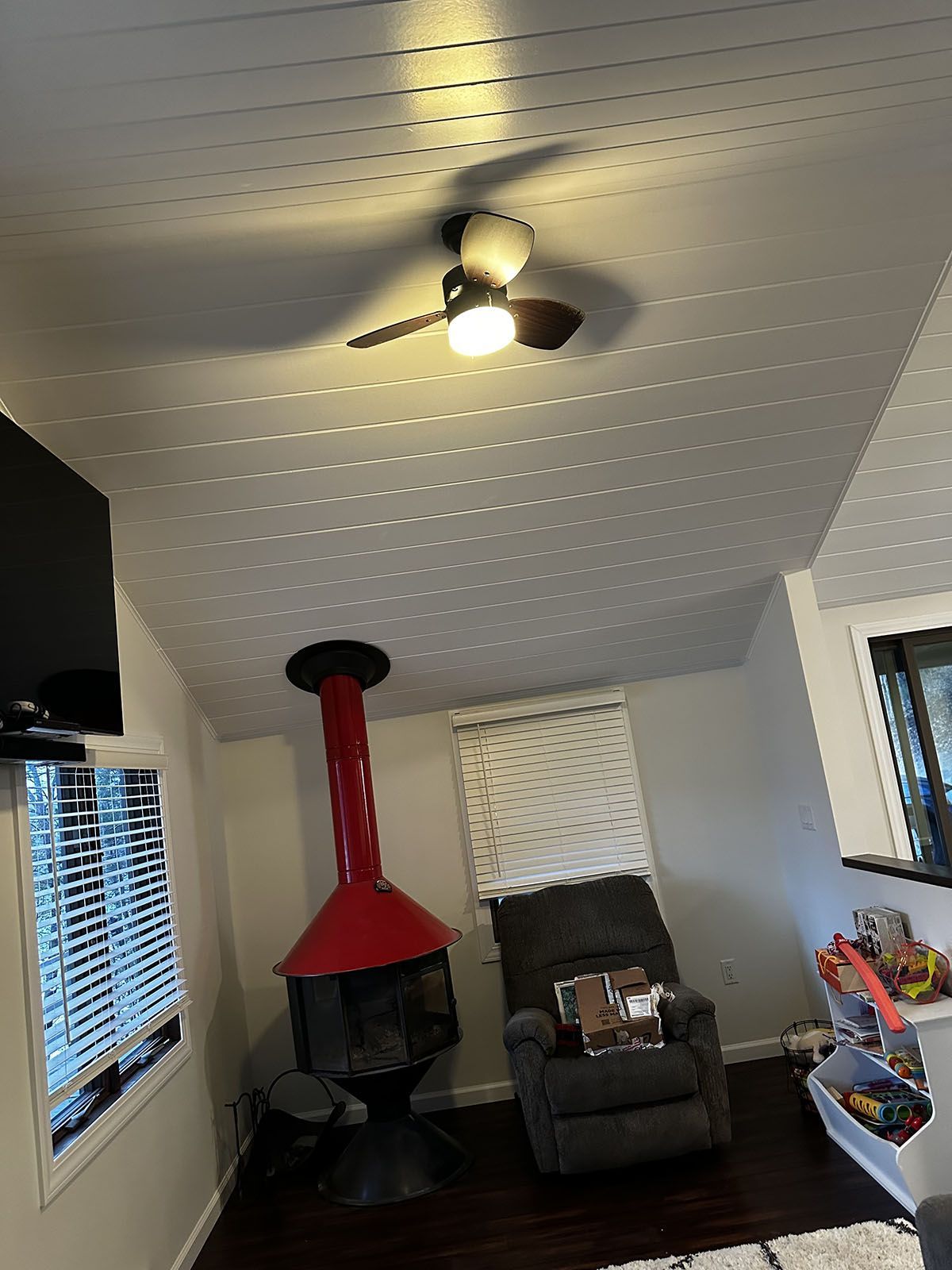 A living room with a fireplace and a ceiling fan.