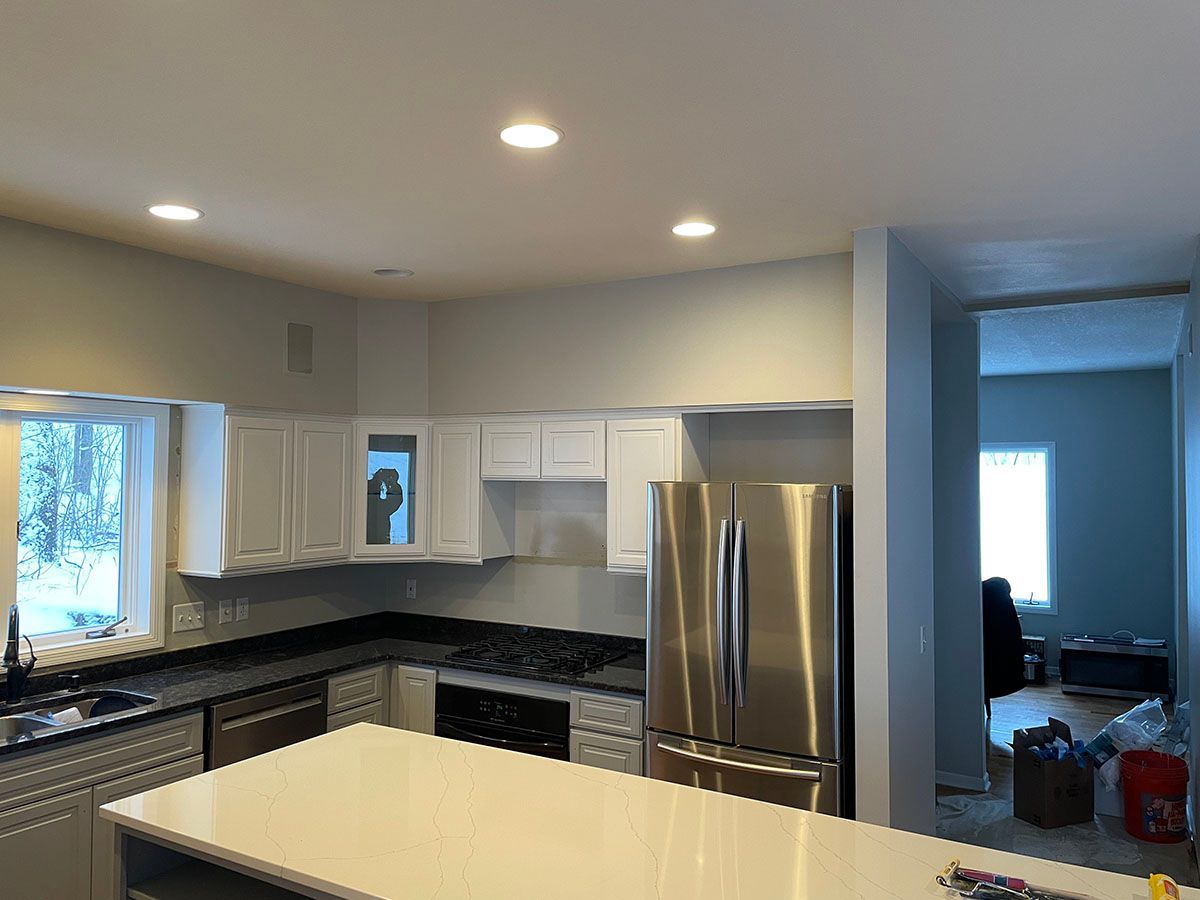 A kitchen with stainless steel appliances and white cabinets.