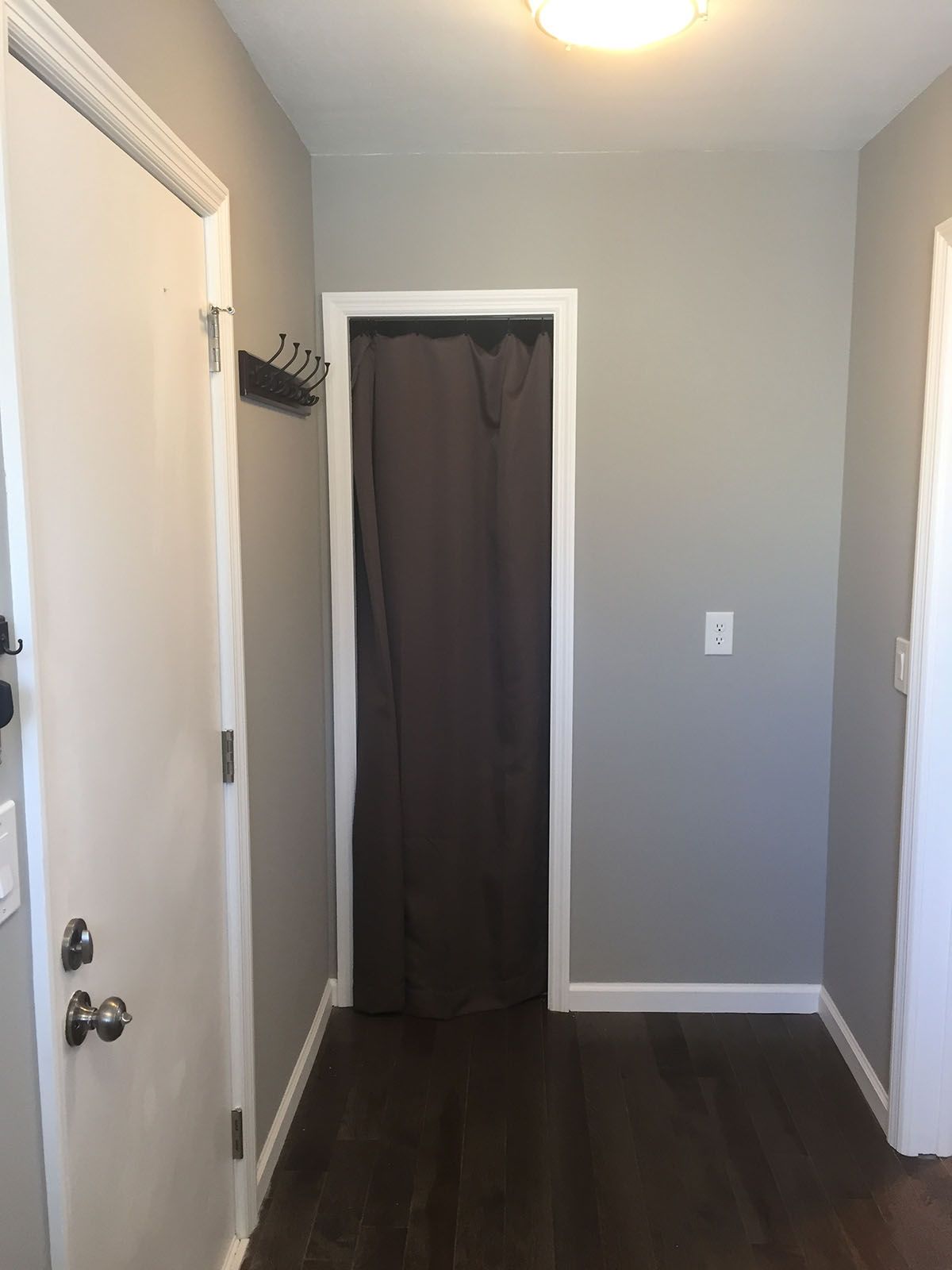 A hallway with a door that has a curtain on it