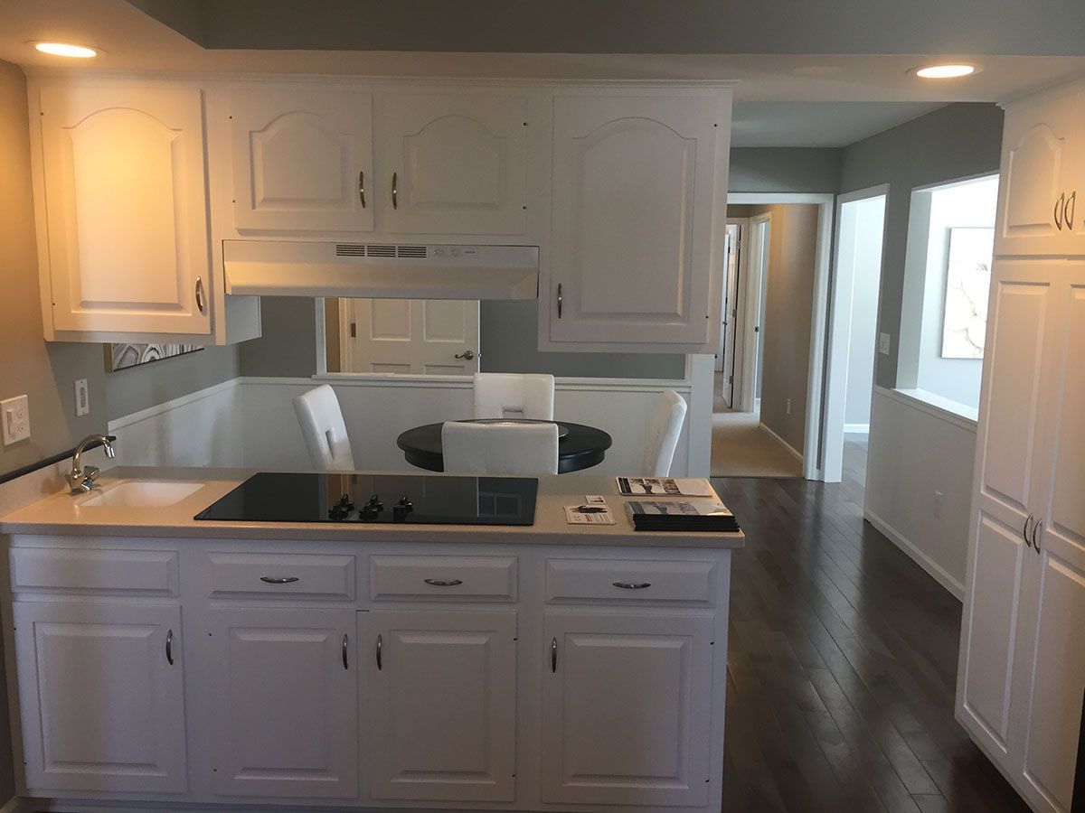 A kitchen with white cabinets and a stove top oven