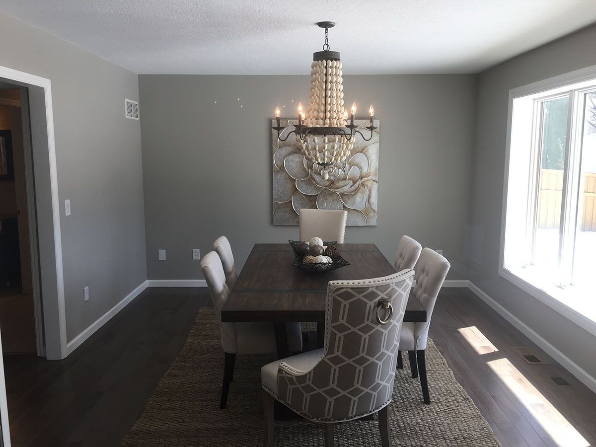 A dining room with a table and chairs and a chandelier