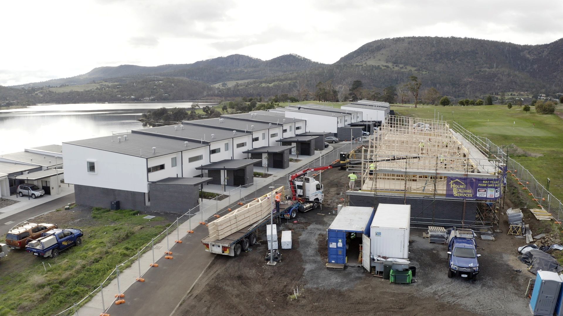 An aerial view of a construction site with a lake in the background.