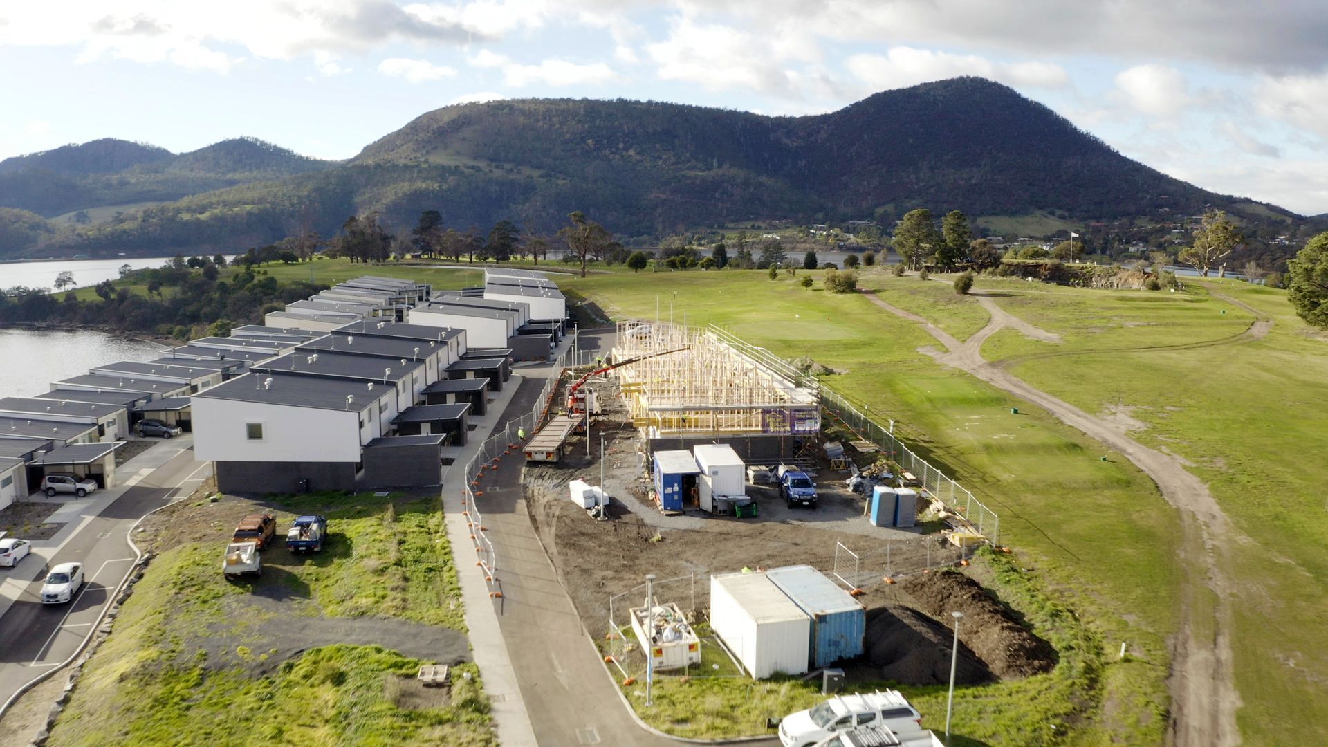 An aerial view of a construction site with mountains in the background.