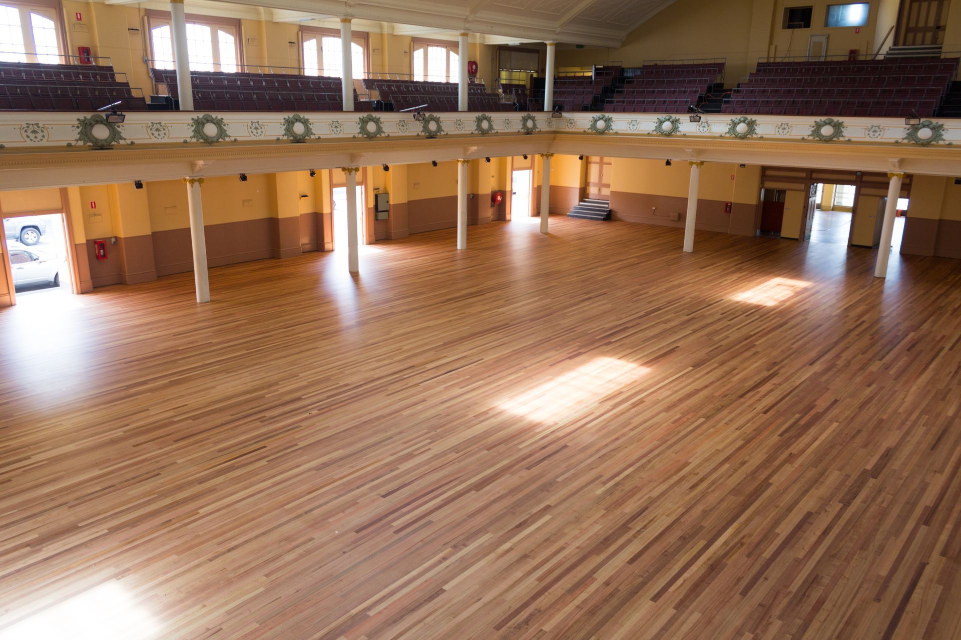 A large room with a wooden floor and a balcony