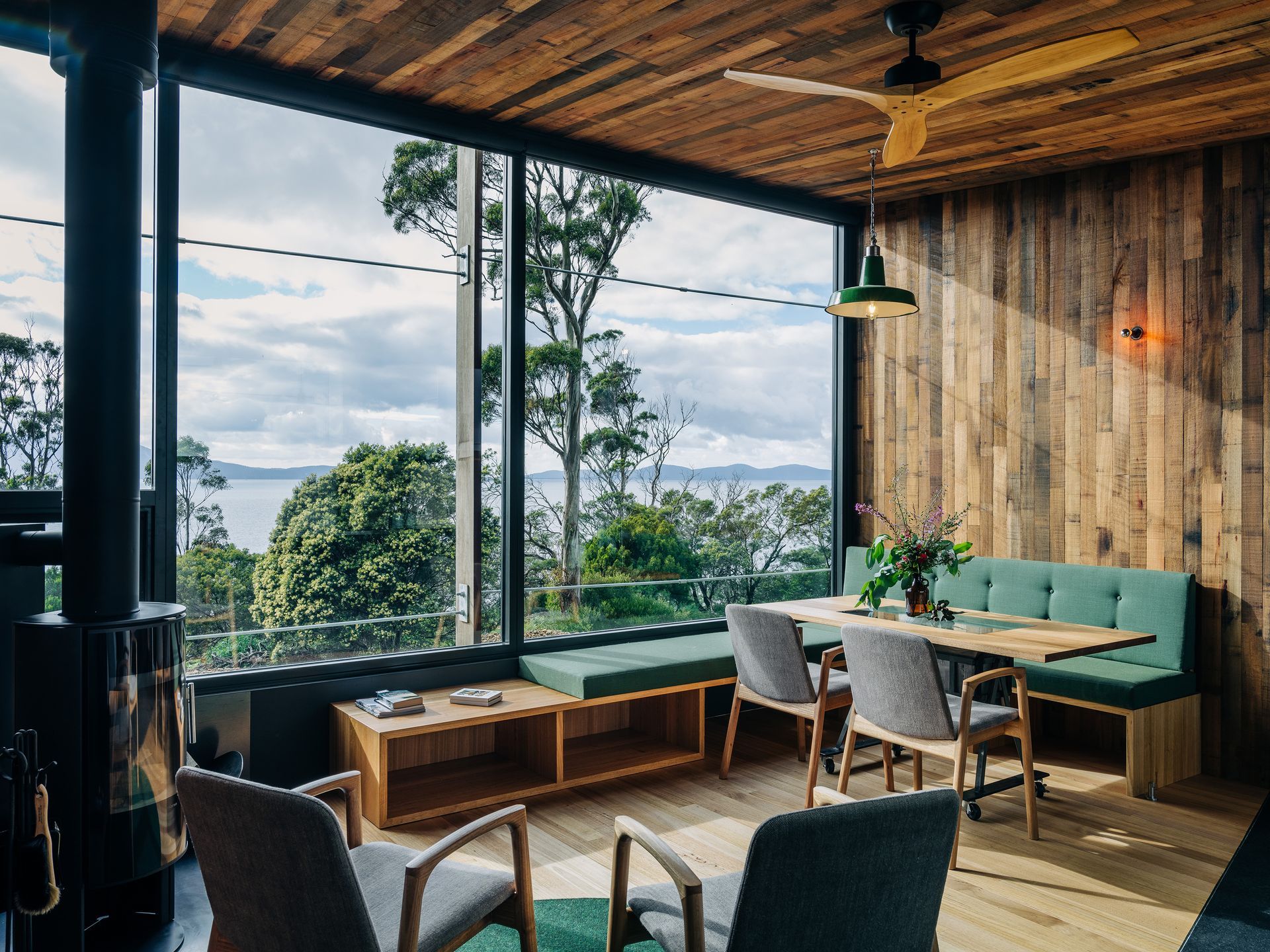 A living room with a table and chairs and a ceiling fan.
