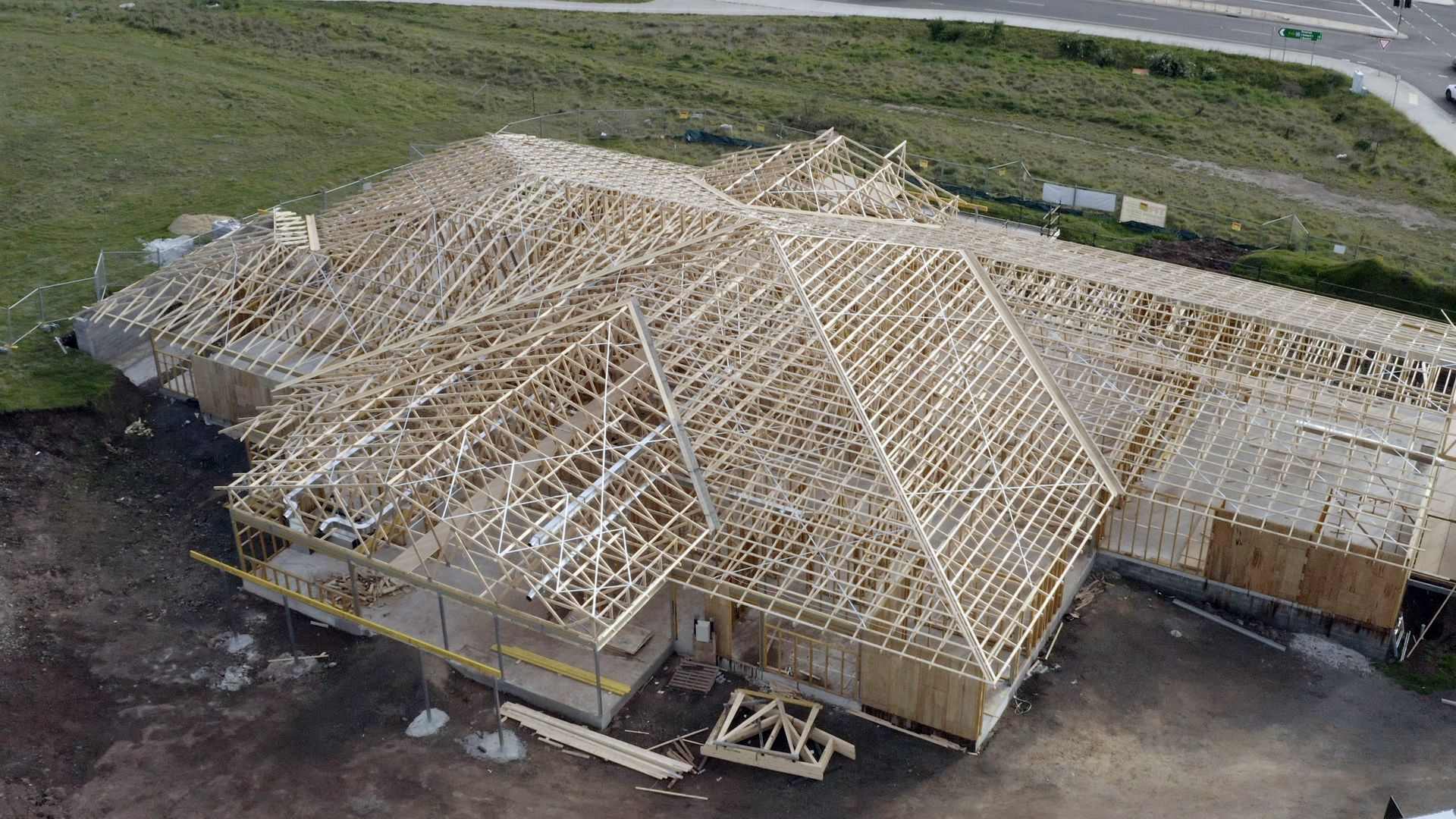 An aerial view of a house under construction with a wooden roof.