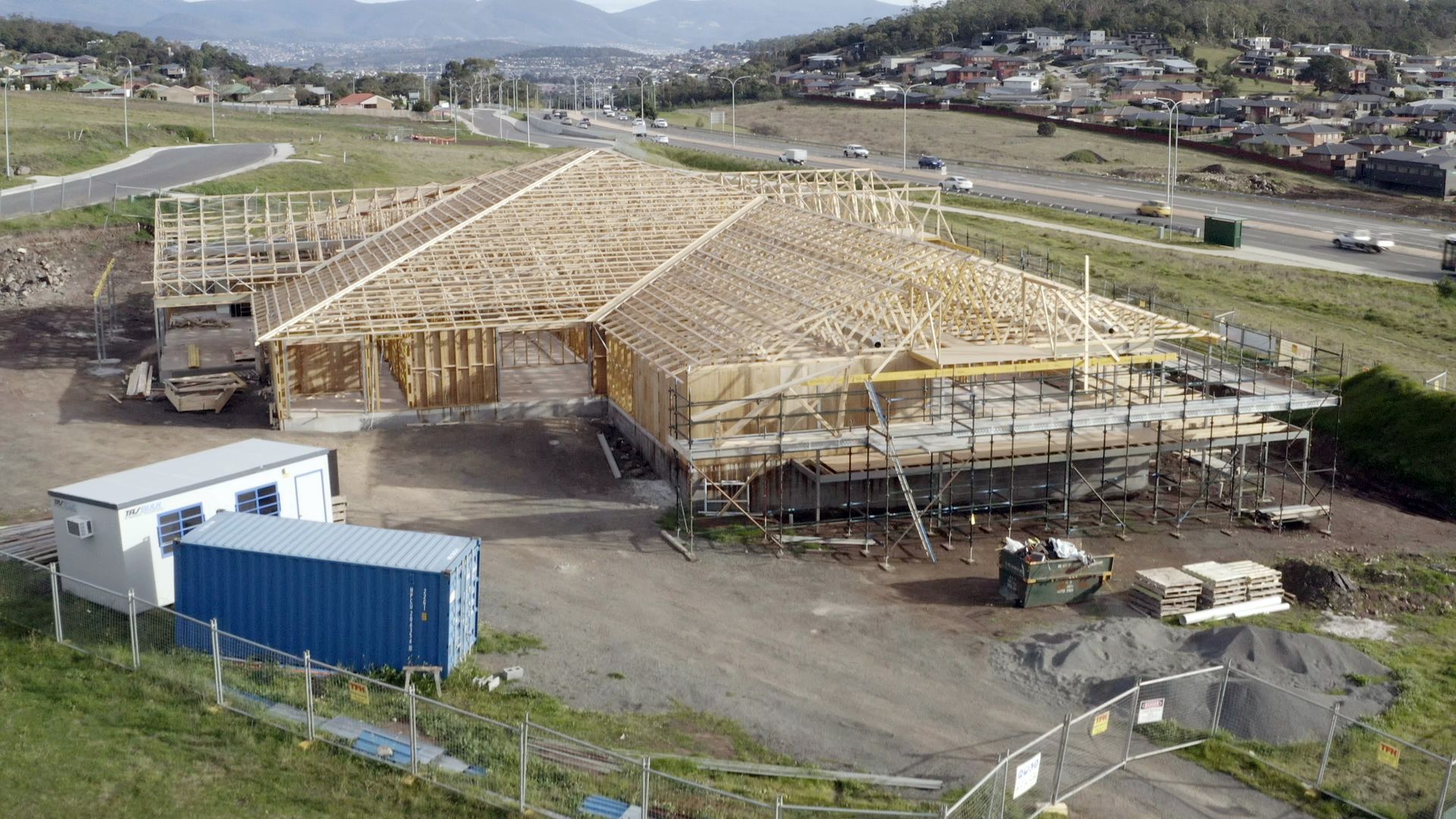 An aerial view of a house under construction in a field.