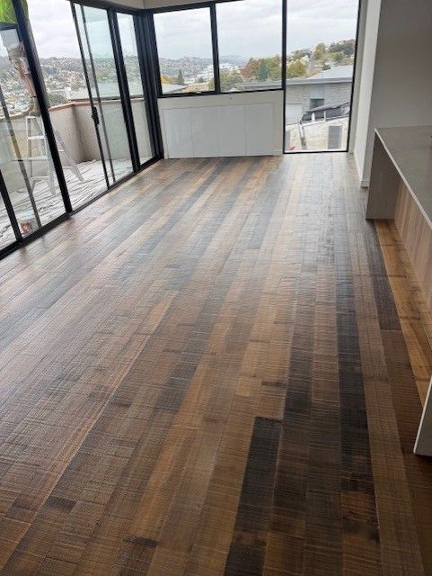 A living room with a wooden floor and sliding glass doors.