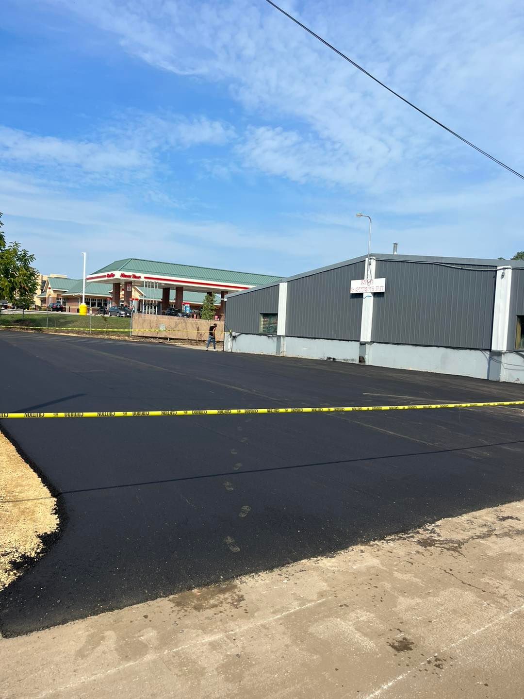 Newly Paved Asphalt Road in Front of a Building
