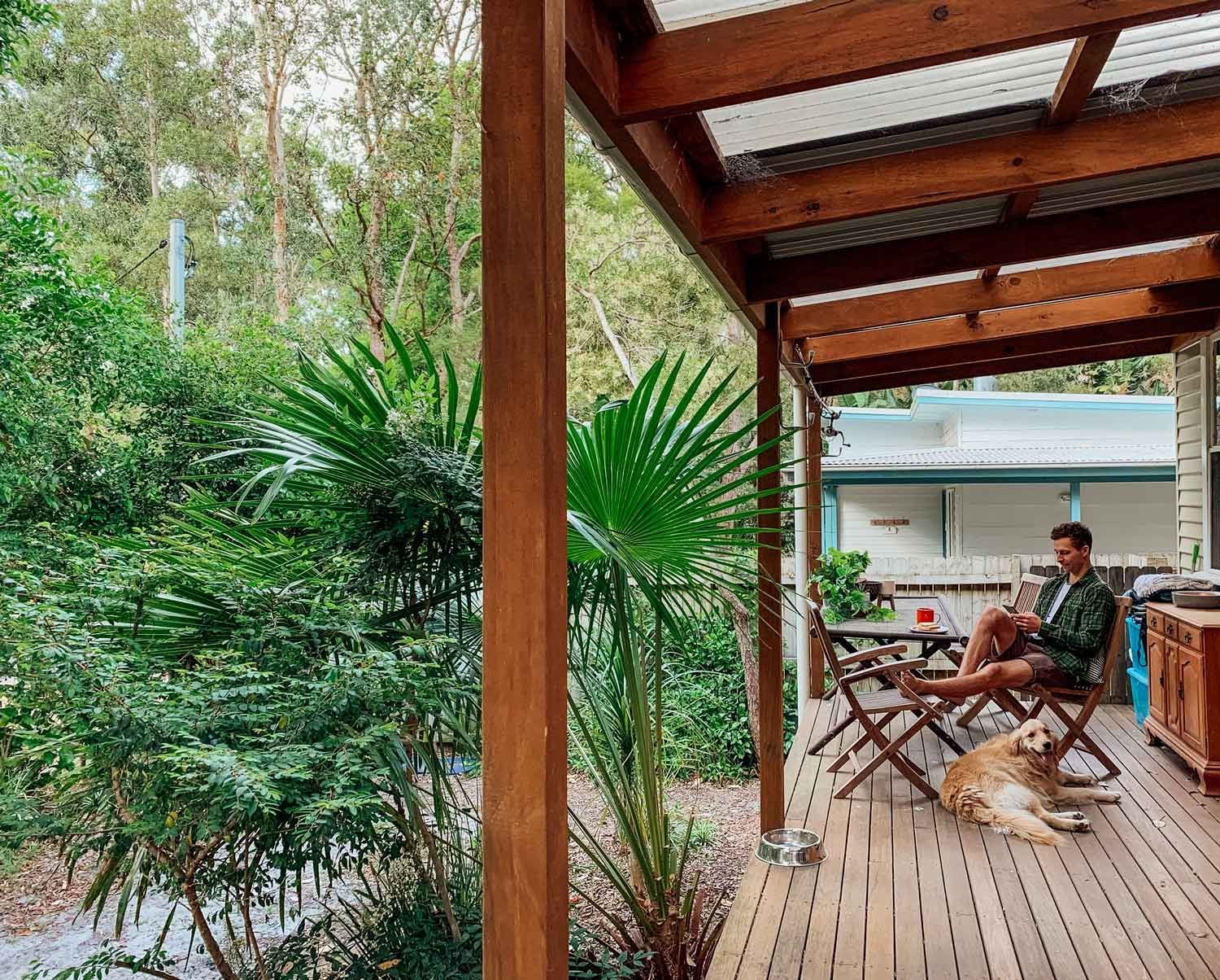 A Man Is Sitting on A Wooden Deck with A Dog | Gold Coast, QLD | Signature Sanding