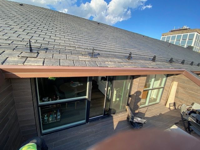 Two men are working on the roof of a house.