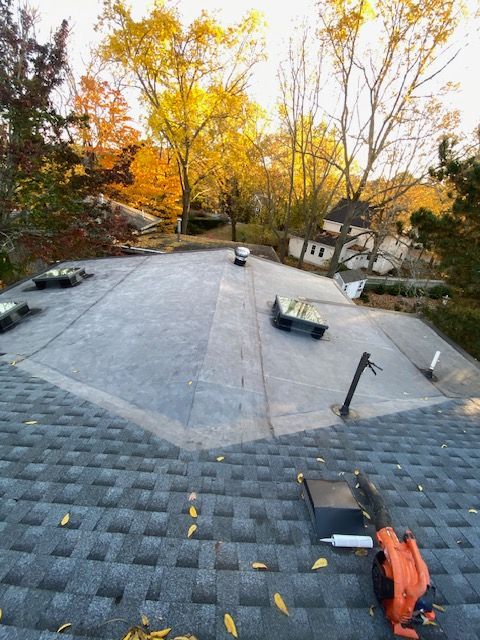 A man is standing in front of a house with a ladder in front of it.