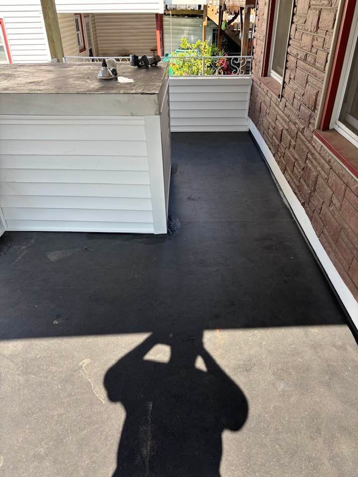 A shadow of a person is cast on the floor of a porch.